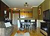 Great room floorplan features sleeper sofa, dining table for 4, and huge flat panel TV.