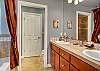 Large bathroom features deep tub, his and her sinks, separate glass shower and commode.