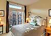 Master bedroom with queen size bed, balcony, and ensuite bathroom.