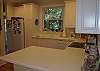 Kitchen has hardwood flooring, newer appliances and a pantry for storage