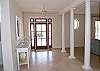 Front entrance with marble tile flooring and stately columns
