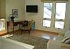 The master bedroom has a digital flat screen TV, desk and loveseat