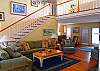 Spacious, open living area with vaulted ceiling and hardwood flooring.