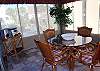 Glass enclosed sunroom is a great place to enjoy breakfast or a game of cards