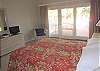 Master Bedroom with queen bed, flat screen TV and deck access