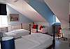 Two twin beds, wood flooring, sitting area, desk and private bath