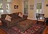 A warm and inviting room with comfortable furnishings, screened porch access