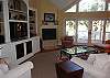 Spacious living area with hardwood flooring, high ceilings and entertainment center