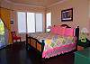 King bed, hardwood flooring TV and access to the screened porch