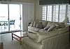 Comfortable living room with extra windows and sleeper sofa.  Great views and custom plantation shutters when you want privacy