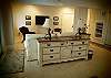 Second living area located on the first level with tile flooring, flat screen TV and wet bar with small refrigerator