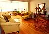 Spacious living area leads to sunroom, new wood flooring