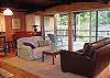 Comfortable and cozy open family room with plenty of wooded views. Flat screen T.V. and piano provide plenty of entertainment.
