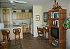 View of TV with VCR, desk and bar.