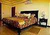 Master bedroom with cozy king size bed, side table and lamp