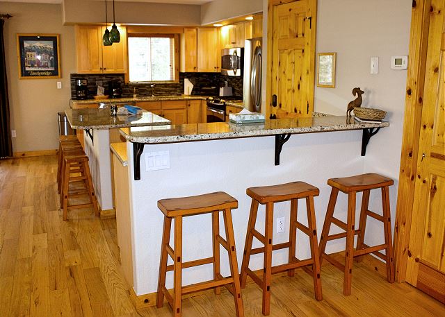 The fully equipped kitchen has new appliances, granite countertops, and a breakfast bar with extra seating. The dining rooms table is big enough for the whole party and the glass sliding doors go out to a private hot tub, outdoor seating, and a grill. 