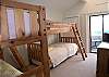 Guest bedroom with two sets of bunk beds, cable TV and sliding doors to the Gulf view balcony.