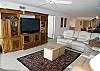 Living room with, huge leather reclining sectional, 46" HDTV and Bose Home Entertainment System.