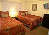 Bedroom with two double beds and LCD cable TV.
