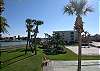 Shuffleboard, volleyball, picnic tables & BBQ grills on the bay next to building 1.