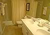 Guest bathroom with double vanity and tub/shower.