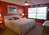 Master bedroom with king size bed, flatscreen TV and adjoining bath.