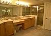A jacuzzi tub,  large tile shower and double vanities in the spacious master bath