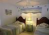 The guest bedroom has twin beds, an adjacent bath with shower and cheerful seaside motif.