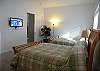 Main level guest bedroom with two queen size beds and flat panel cable TV.