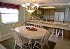 The dining table seats 6 and there are four stools at the dining counter.