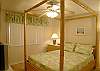 Guest bedroom with queen size bed, cable TV and adjacent bath with tile shower.