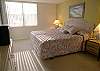 Master bedroom with king size bed, cable TV, walk-in closet & sliding doors onto the balcony.