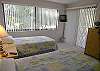 Guest bedroom with twin beds, cable TV/VCR, sliding doors to the balcony and adjacent bath with tub/shower.