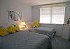 The guest bedroom has one queen size bed and a twin bed too.  The adjoining bath has a tile shower.