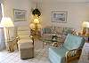 Living room with cool ceramic tile floors, comfortable seating and a queen size sofa bed.
