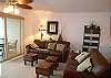 Living room with leather sofa bed, loveseat & Gulf front balcony.