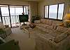 Living room with lots of seating and sliding glass doors to the beachfront balcony.
