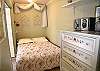 Cozy & romantic sleeping nook with double bed has louvered doors for privacy.