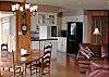 The dining area opens to the kitchen and is adjacent to the living room with views of the beach.