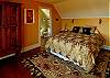 Find a wall of east facing windows in this spacious master bedroom located on the upper level of this three story home