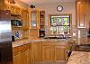 Beautifully stocked kitchen with granite counters and SS appliances.