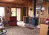 The cabin style living room at Karemar Cove has a cozy wood stove and medley of decor.