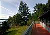 Deck overlooks sloping yard down to the water.