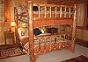 The upstairs bedroom, also with water view, offers queen size log bunk beds.