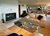 The great room room features seating in front of a wood burning fireplace.