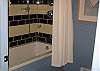 The beautiful full bathroom of the Paddock also offers a shower stall, toilet compartment, and two custom sink consoles.