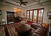 A wall of French doors opens to a deck that wraps around the water side of the home.