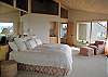 The oversize master bedroom offers a king size bed, private patio, walls of windows, & mirrors to reflect the view.