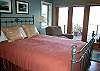 This bedroom is just off the living room and offers a queen size bed, double doors to the deck and a cozy reading chair.