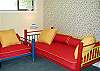 This bedroom offers a TV, two twin day beds and a cushioned window seat.
